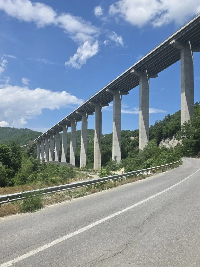 A huge pilon bridge spanning a valley, seen from underneath.