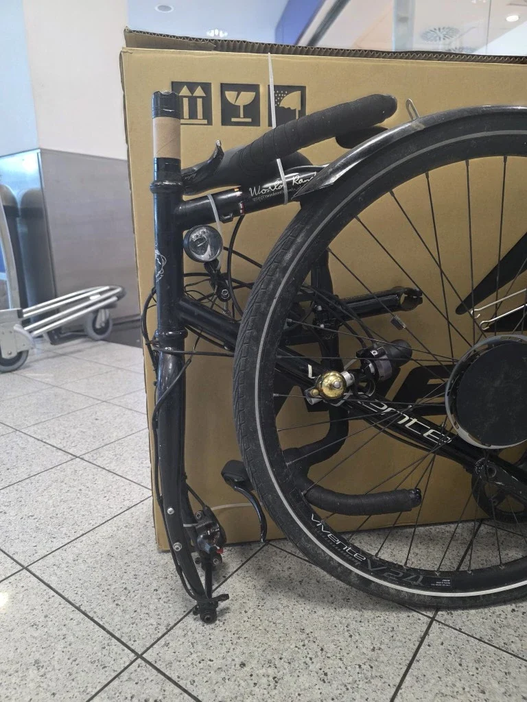 A vivente bikes dismantled and ready for packing next to a carton.