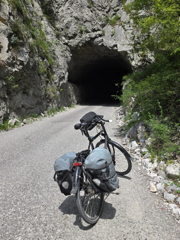 A vivente bike standing in front of a tunnel that is very very dark.